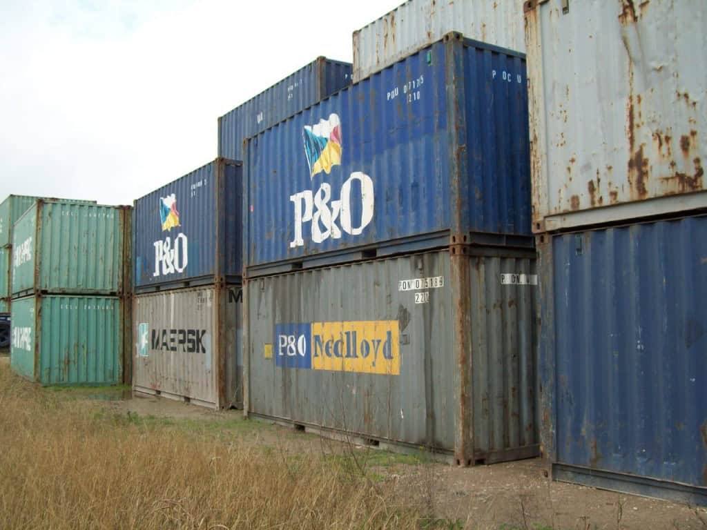 Back of stacks 2 and 3 - Lummid Used shipping containers in a yard still marked with the names of the shipping lines that first owned them