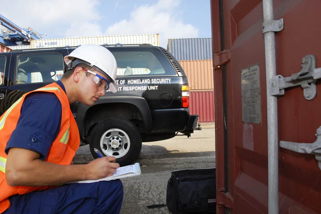 Worker inspecting shipping container for export quality control