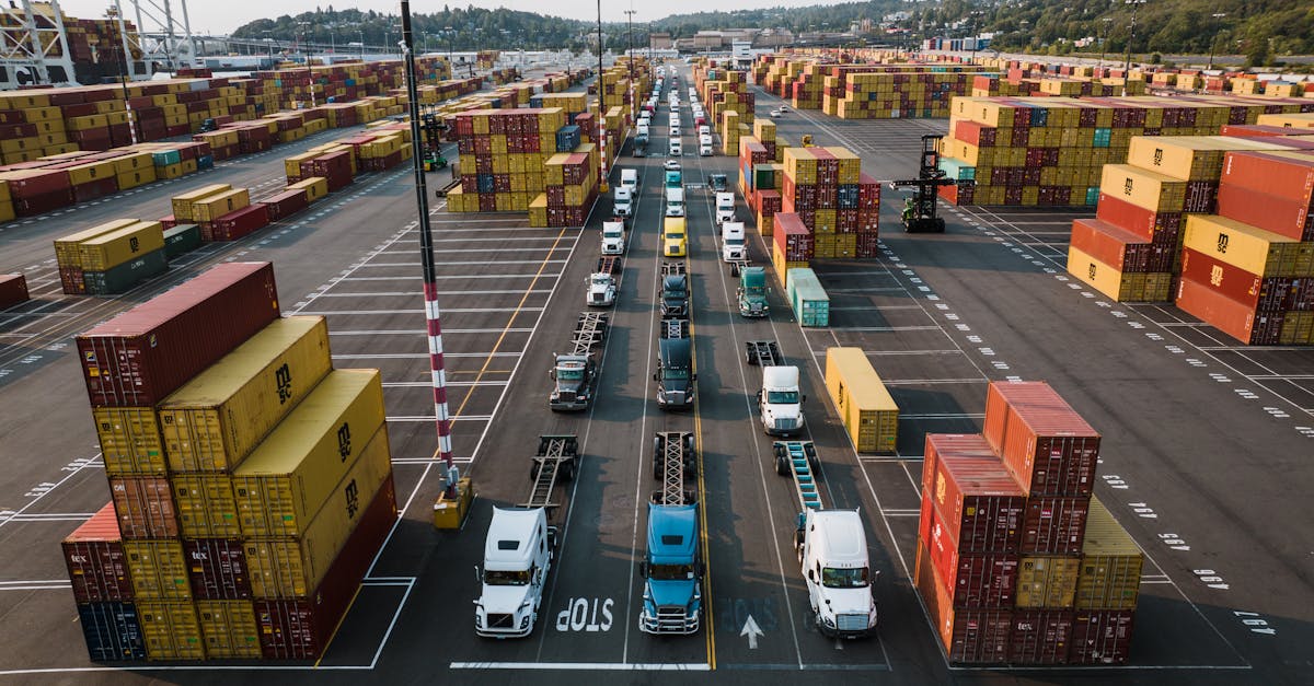 Trucks driving through lanes of stacked containers at a port terminal