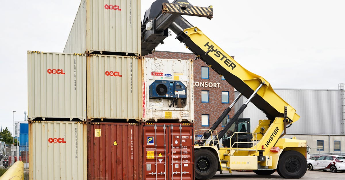 Hyster reach stacker lifting a white OOCL container in a depot