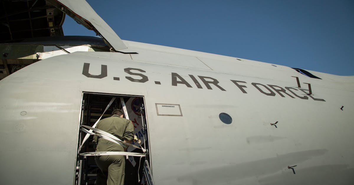 U.S. Air Force aircraft with a crew member ascending the stairs into the side door.