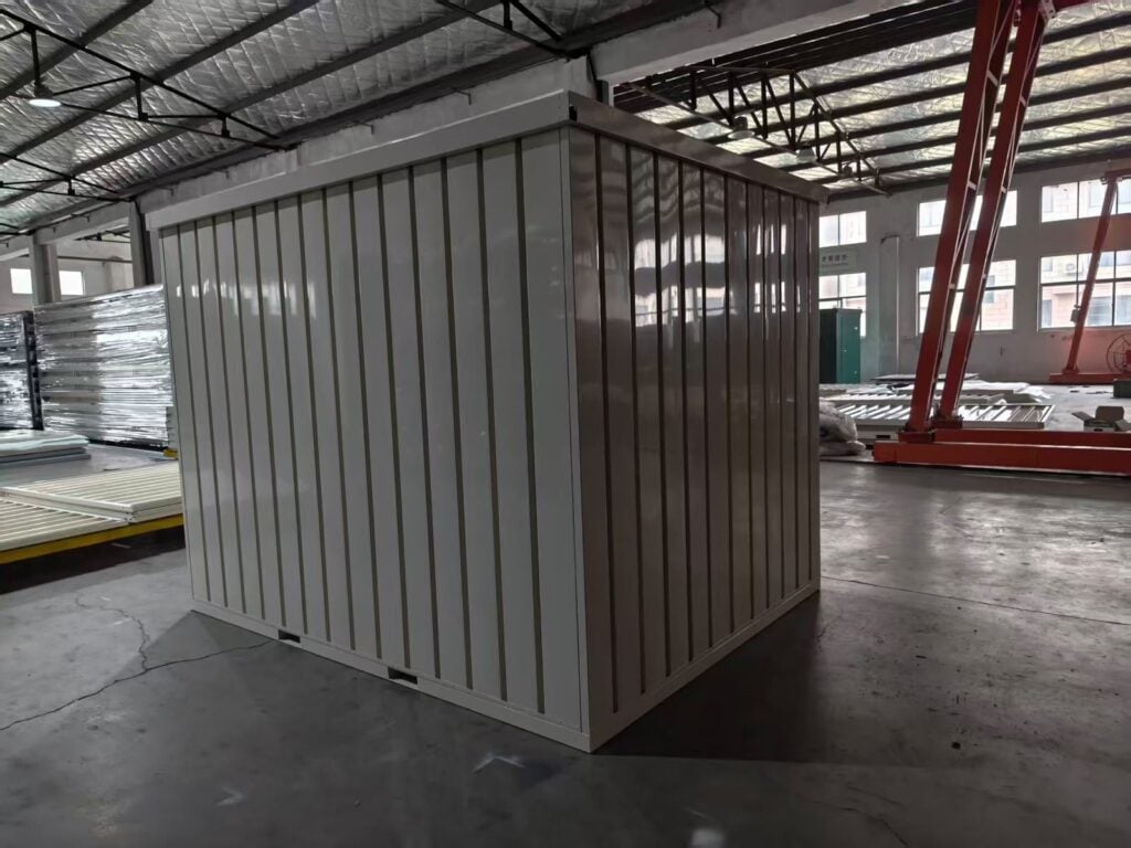 Side wall of a white 10ft pop-up container with corrugated steel panels and forklift pockets